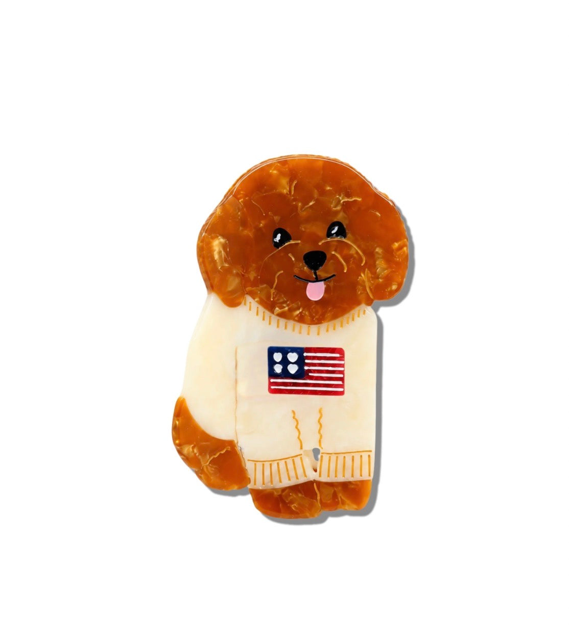 A small dog-shaped claw clip, featuring a brown and amber marbled texture. The dog is wearing a cream-colored sweater with a small American flag patch on the chest, set against a plain white background.