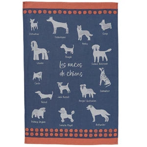 A rectangular kitchen towel with a navy blue background featuring white illustrations of various dog breeds, French text reading 'Les races de chiens', and orange borders with orange dots at the top and bottom.